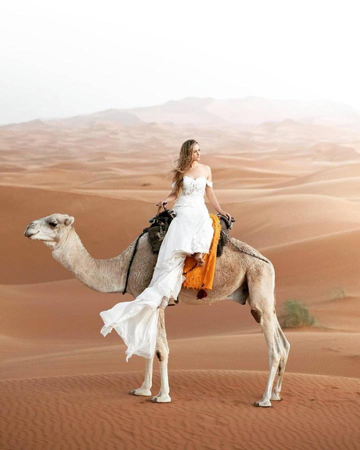Sahara Majestic Luxury Camp Hotel Merzouga Exterior photo A woman riding a camel in the desert